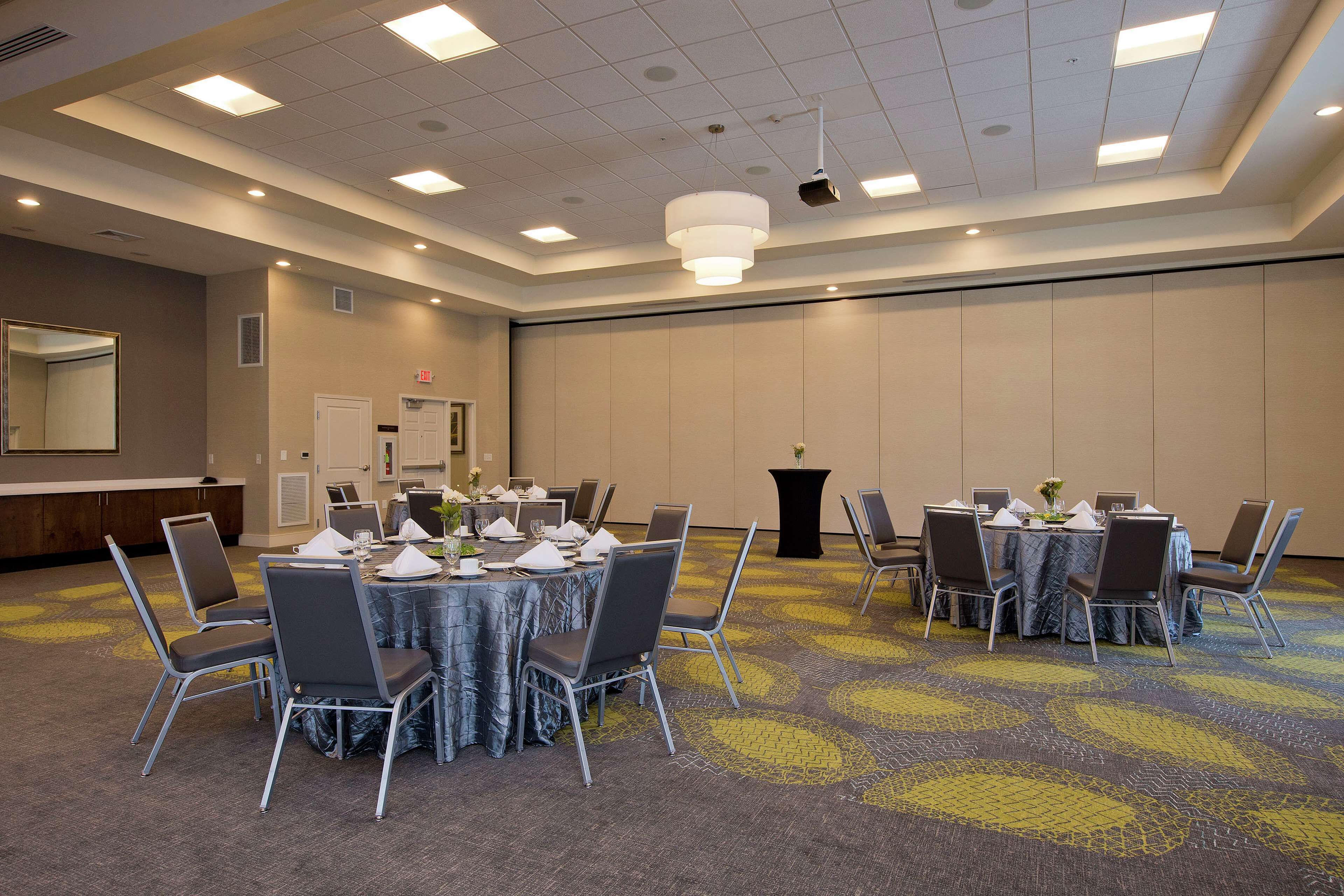 A conference room with a round table, chairs, and a projector.