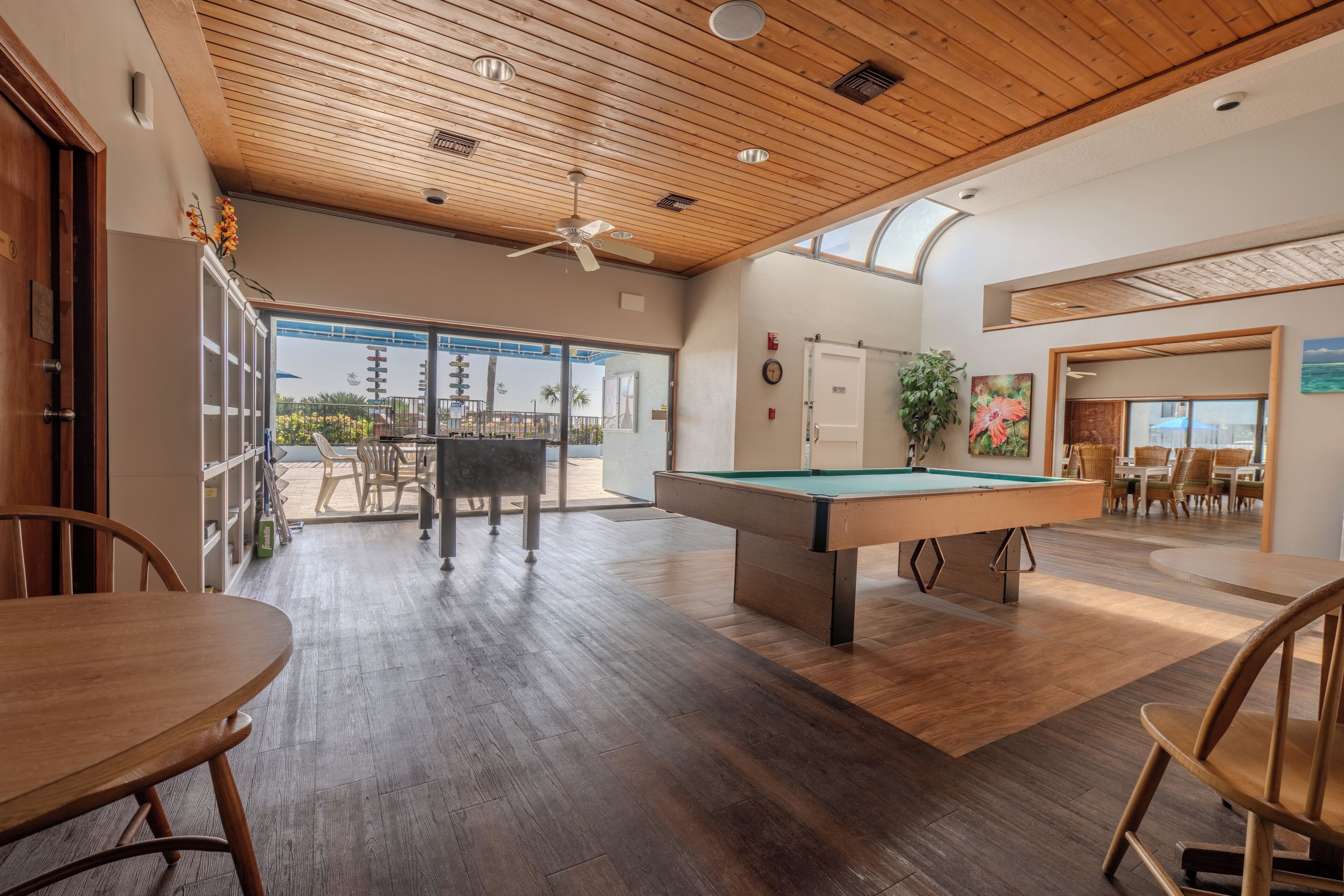 A pool table, wooden ceiling, and a view of the outdoors.