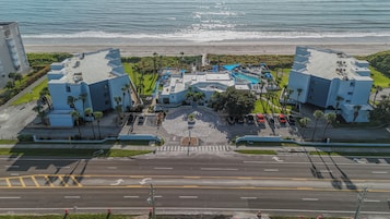 Um hotel com piscina, estacionamento e vista para a praia.