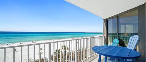 A balcony with a view of a beach and ocean.