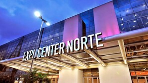 The exterior of Expo Center Norte with a modern glass facade and illuminated signage. - Hotel Diamante (São Paulo)