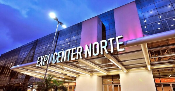 Exterior del Centro Expo Norte con fachada de vidrio moderna y señalización iluminada.