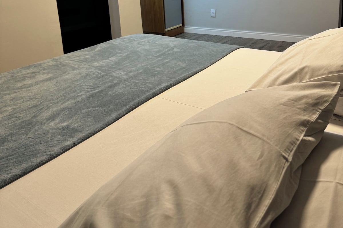 Een slaapkamer met een bed, een kledingkast en een klein bureau.
