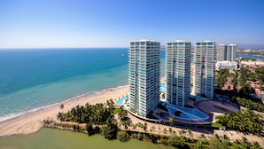 Ein hoch aufragendes Hotel mit Pool und Strandzugang, mit Blick auf einen Strand und den Ozean.
