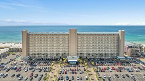 A large hotel with a long facade overlooking a beach and ocean. - Summit Beach Resort by Panhandle Getaways (Panama City Beach)