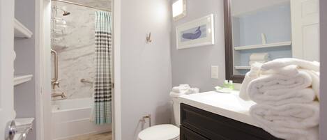 A bathroom with a shower, toilet, and vanity.
