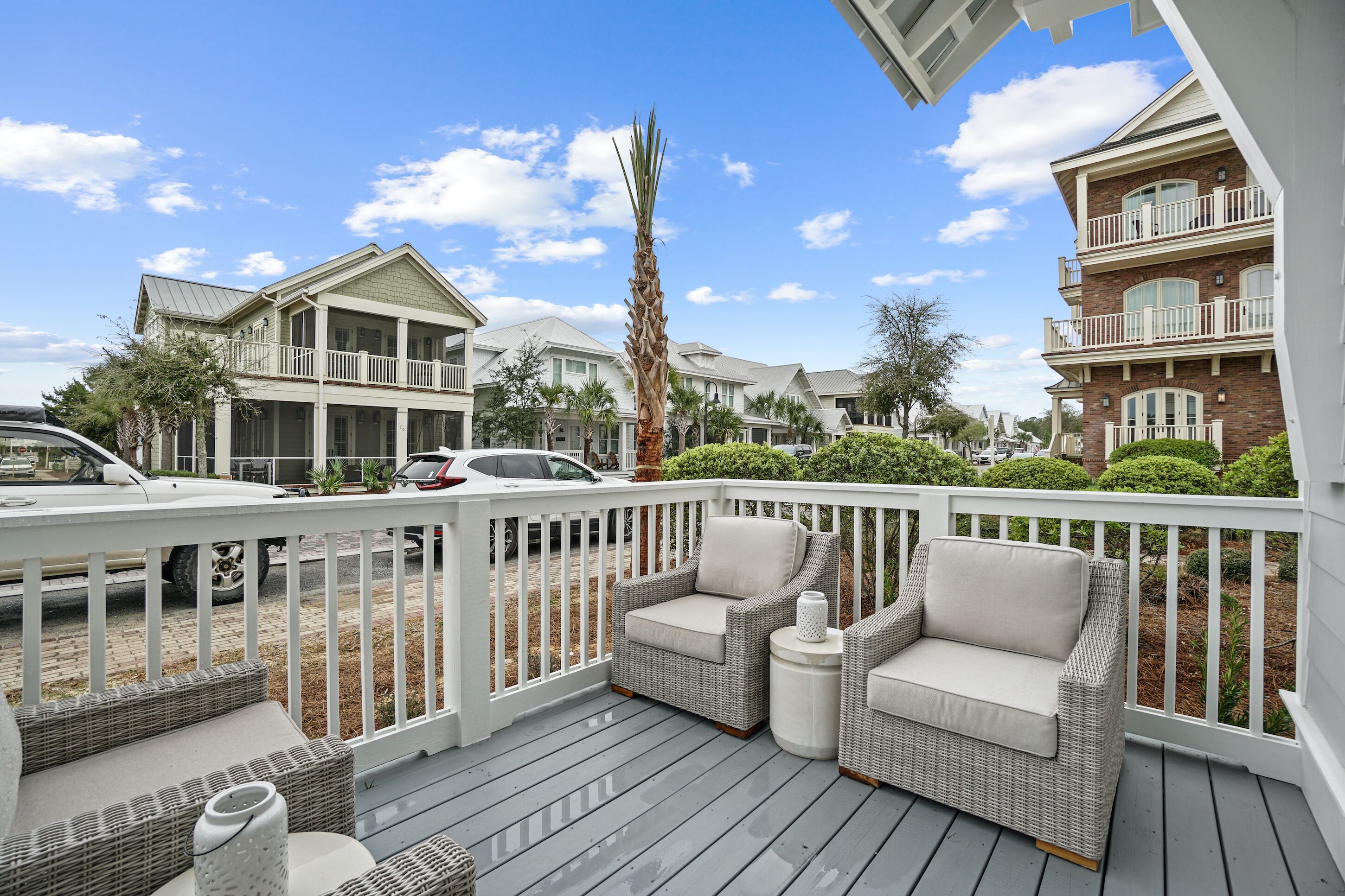 A deck with wicker furniture and a white railing.
