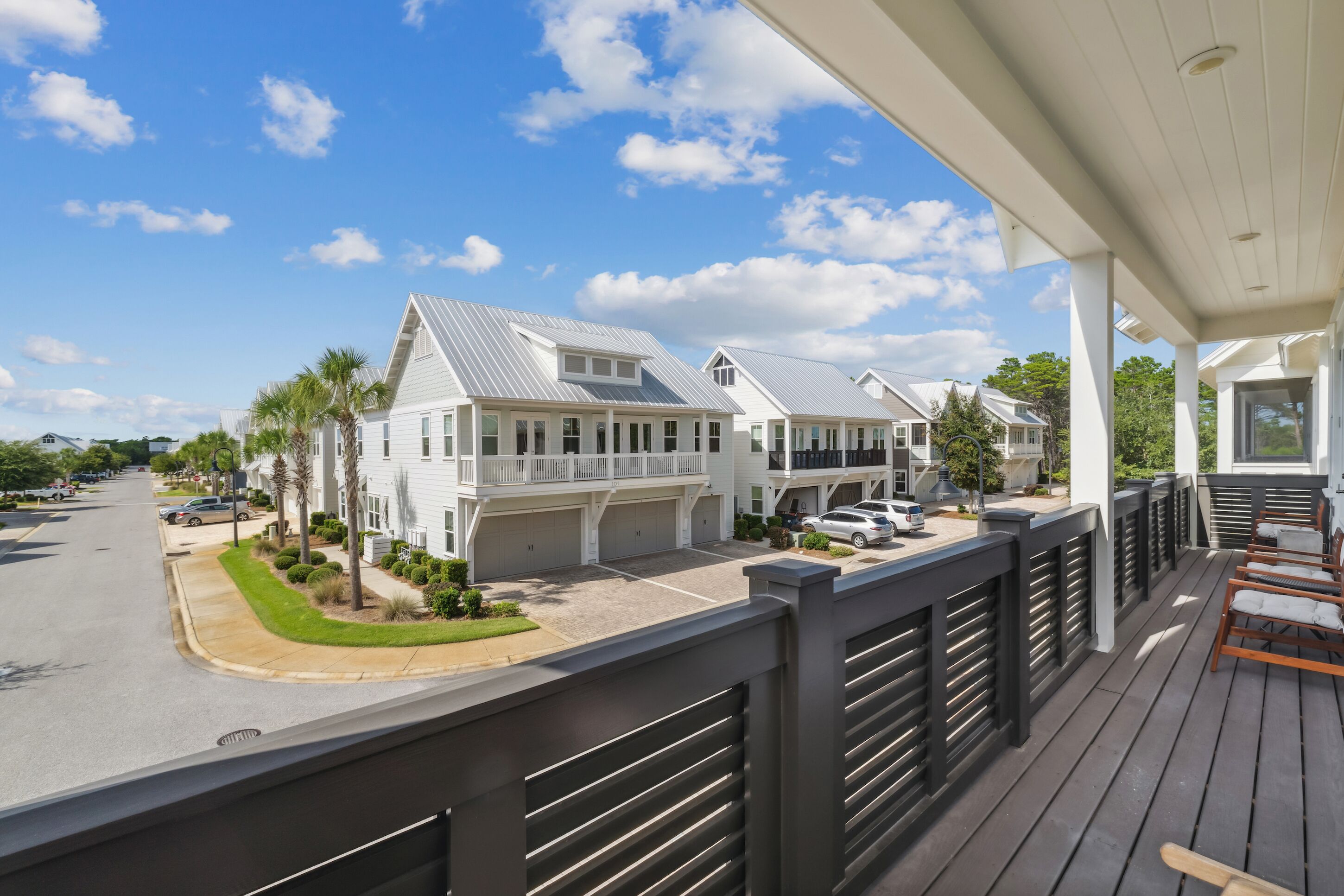 A residential area with white houses, a covered porch, and a street view.