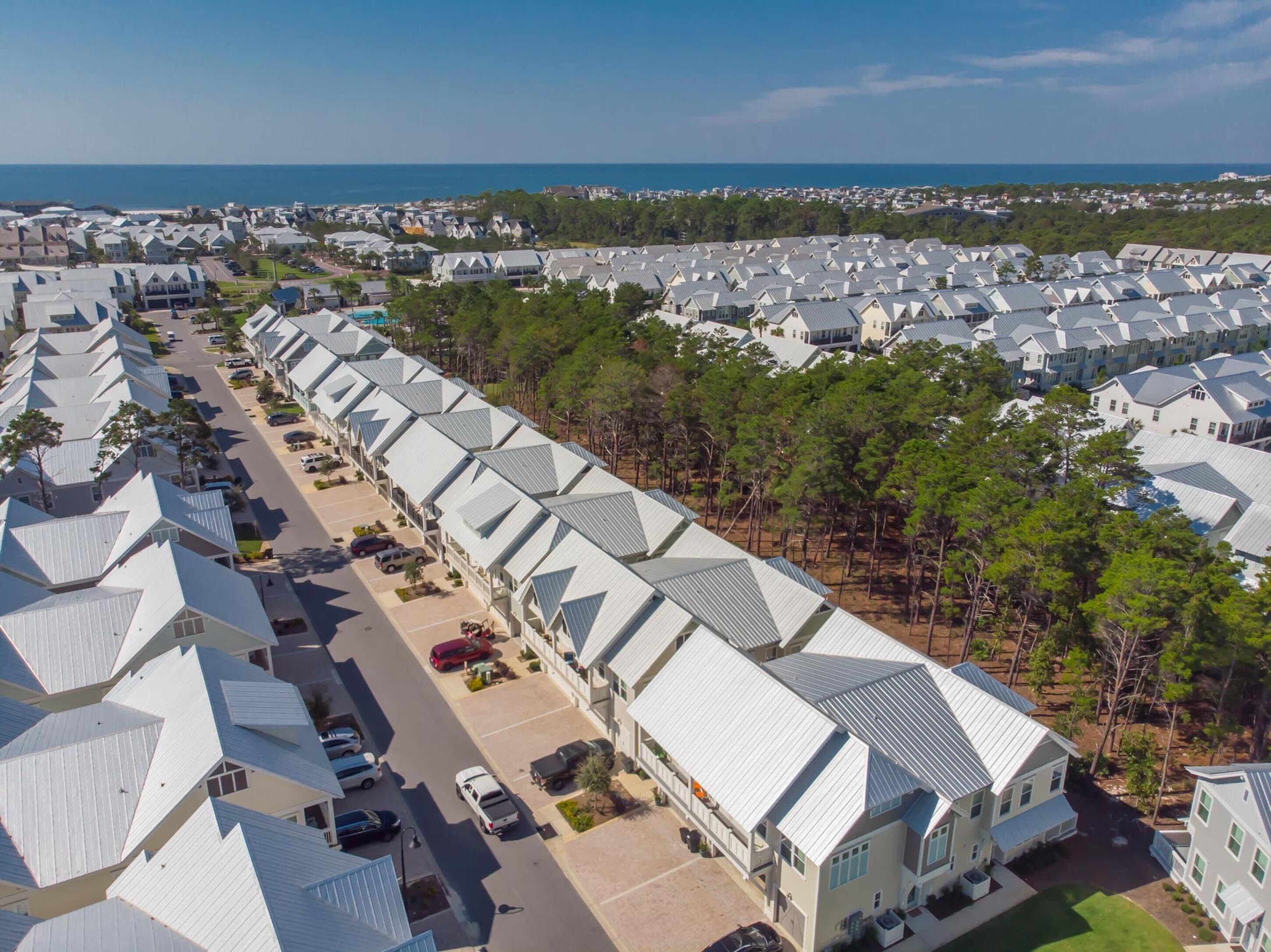 Un quartier résidentiel composé de plusieurs maisons dotées de toits à deux versants et bordé d’une rue principale.
