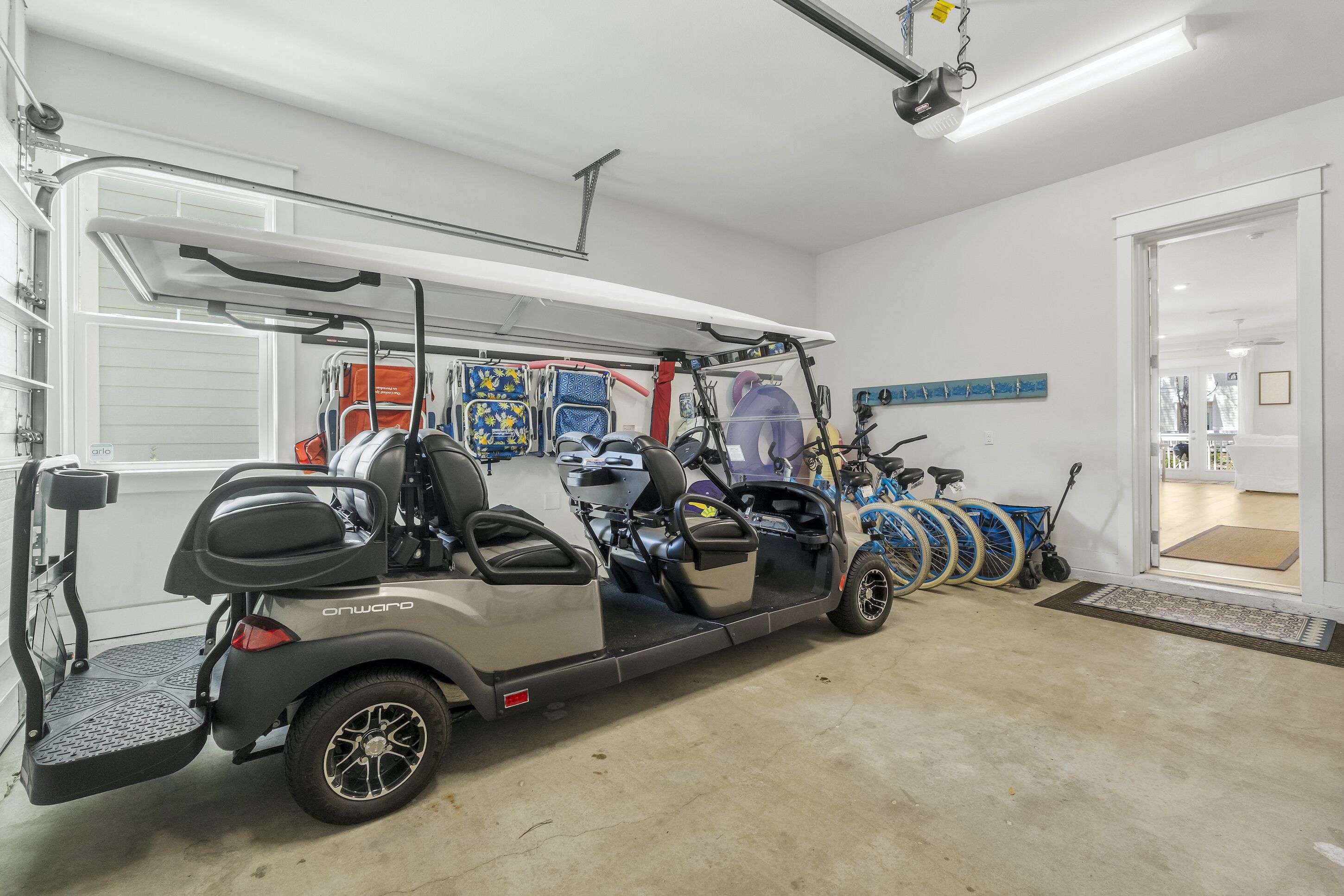Un garaje con un carrito de golf, una silla de ruedas y un scooter.