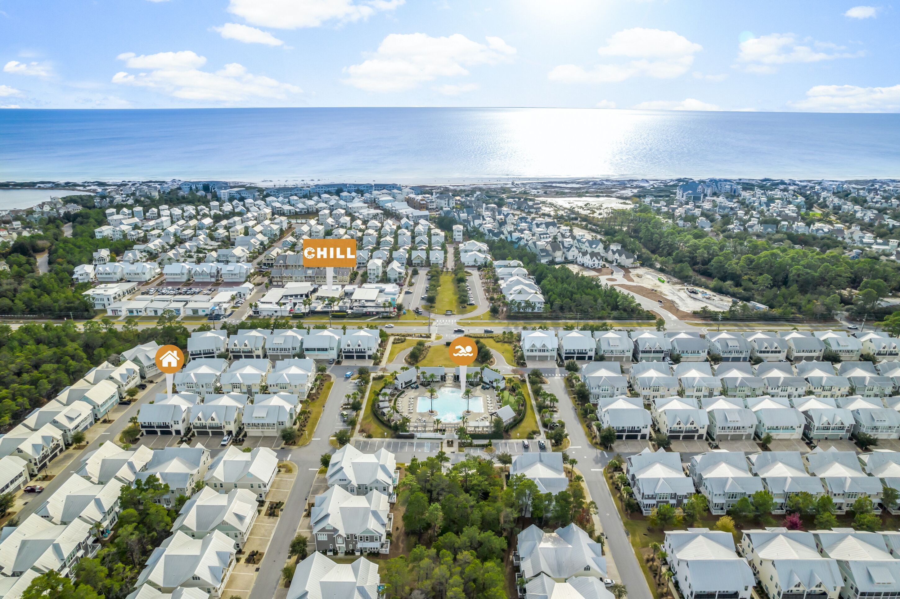 Vista aérea de una zona residencial costera con un parque circular central y varias filas de casas.