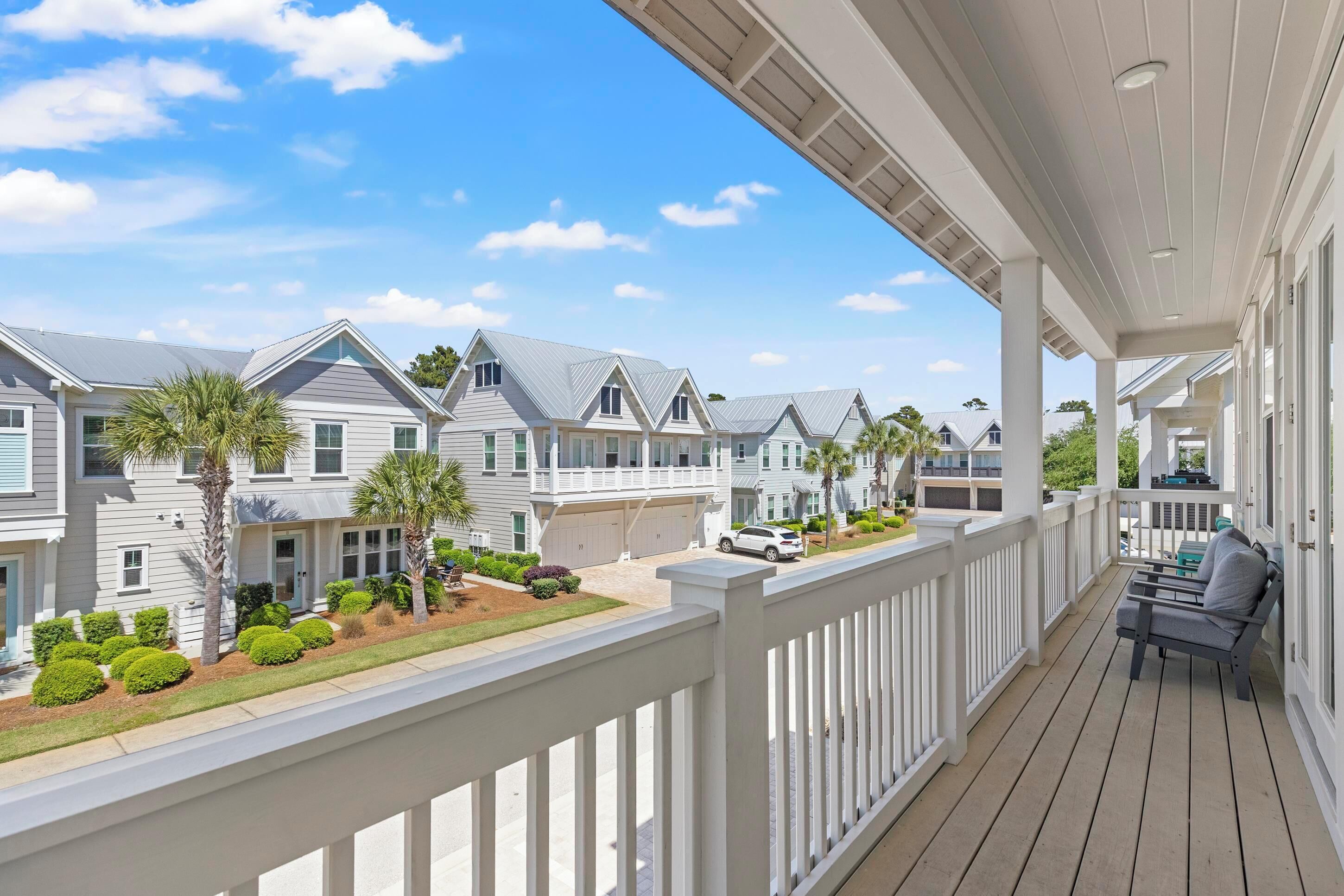 A residential building with a covered porch, multiple windows, and a well-maintained lawn.