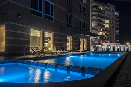 Una piscina al aire libre de temporada, sillones reclinables de piscina