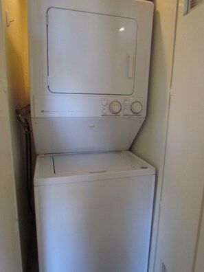 A compact, white, two-door laundry machine with a front-loading design, located in a narrow hallway. - Next to Four Season Hotel, Luxury Apartment (Los Angeles)