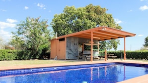 A swimming pool with a covered patio area, a barbecue grill, and picnic tables. - Gidgee Inn Motel (Cloncurry)