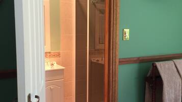 A bathroom with a shower, toilet, and sink.