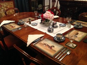 A formal dining table set with blue and white china, silverware, and a vase of pink flowers. - The Laurels B&B Kangaroo Valley (Barrengarry)