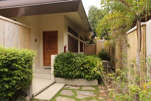 Ein traditionelles japanisches Haus mit Holztür, Kiesweg und Bambuszaun.