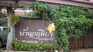 A building with a signboard featuring Thai script and a phone number. - Baan Krittika (Udon Thani)