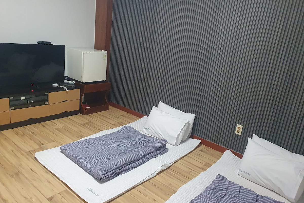 A hotel room with a bed, a TV, and a minibar.