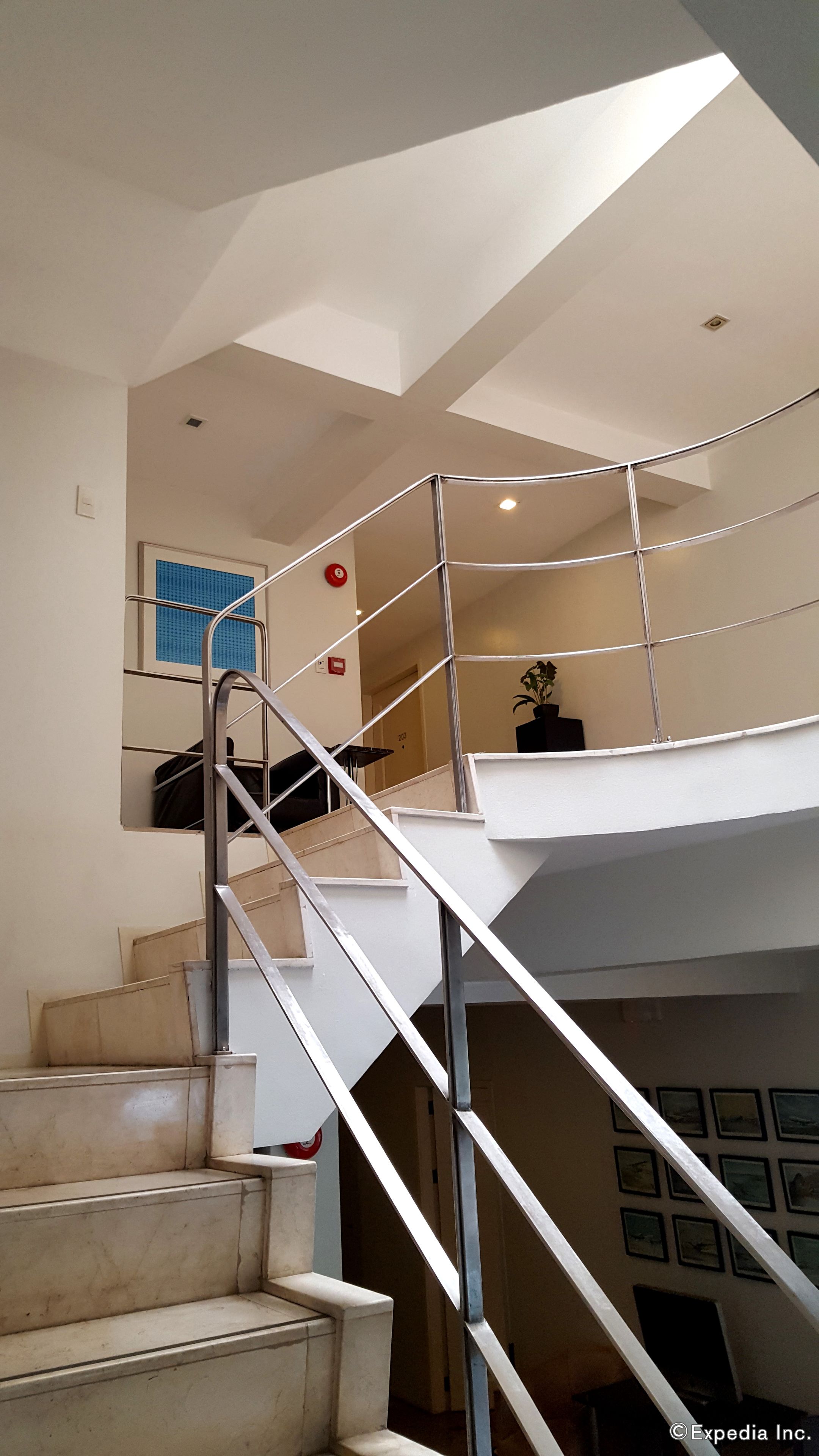 A modern staircase with metal railings leading to an upper floor.