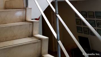 A modern staircase with metal railings leading to an upper floor.