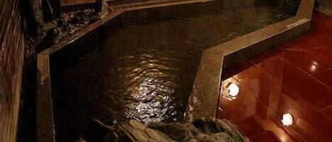 A stone-tiled wall with a built-in hot tub.