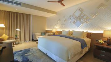 Une chambre d’hôtel moderne avec un grand lit, un ventilateur de plafond et un panneau décoratif mural.