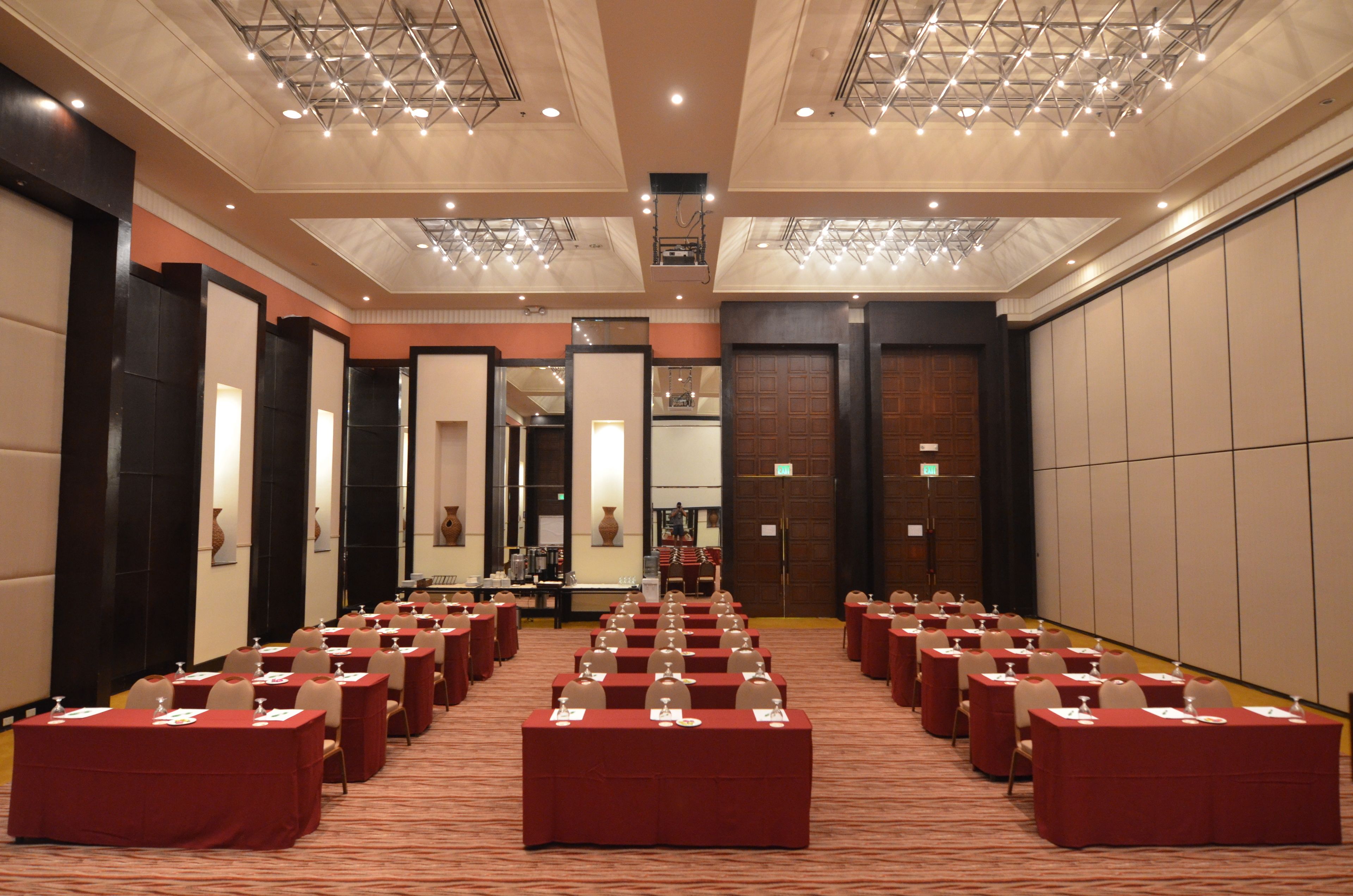 A conference room with rows of tables and chairs, equipped with nameplates and water glasses.