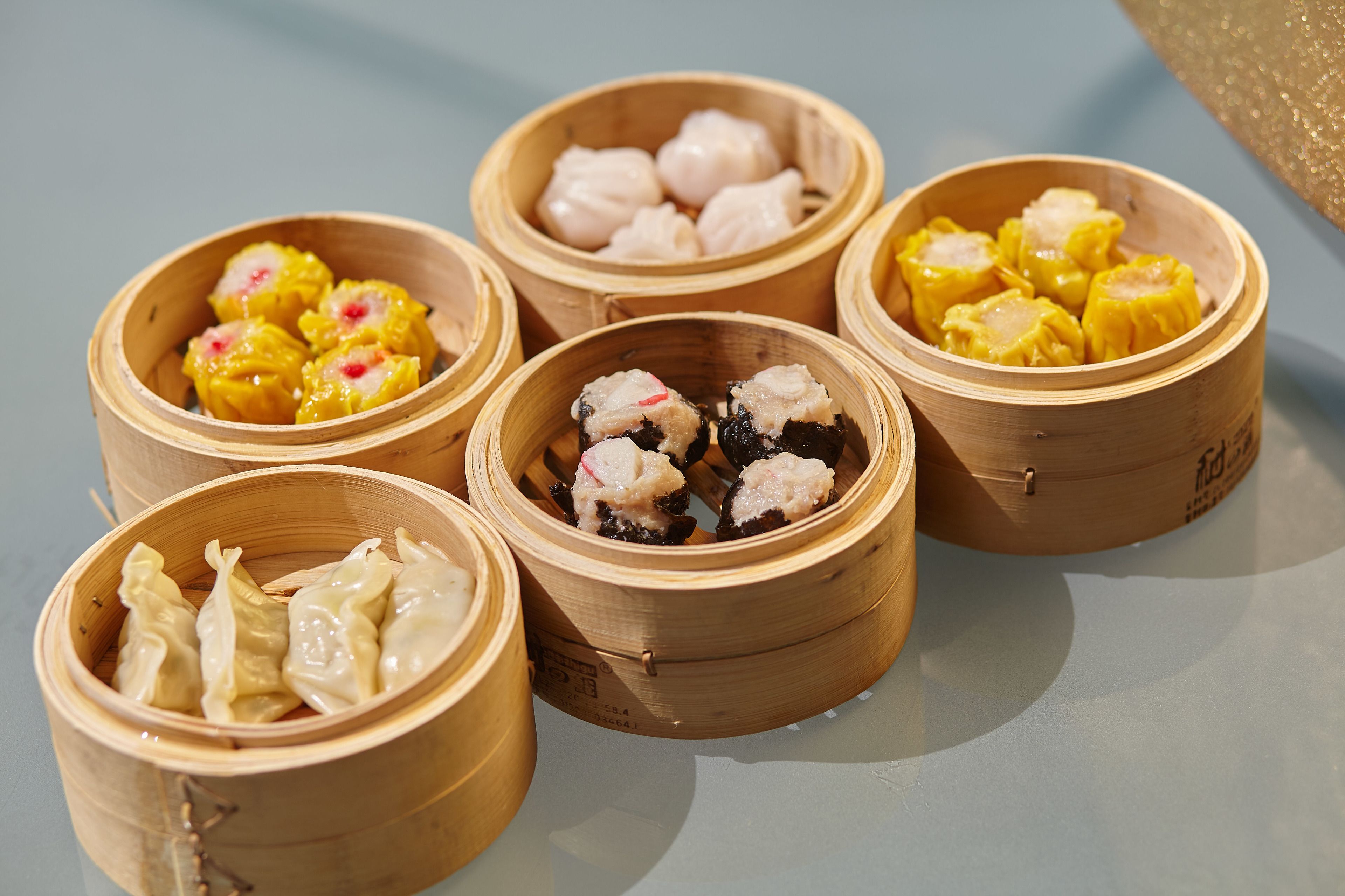 Six bamboo steamers with various dumplings.