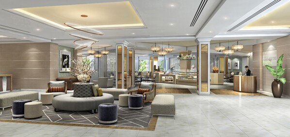 Un lobby moderno de hotel con una zona de estar central, una recepción y vistas al área de cocina.