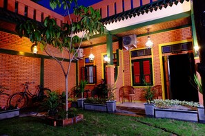 Un patio con un edificio de ladrillo, plantas en macetas y una bicicleta.