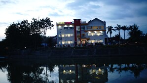 A hotel with a modern design, featuring multiple floors and a prominent entrance. - New d'Dhave Hotel (Padang)