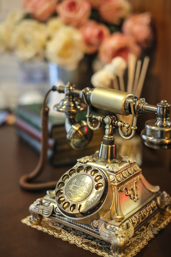 Um telefone antigo de disco rotativo sobre uma base decorativa com desenhos elaborados.