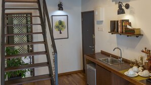 A kitchen with a wooden counter, a sink, and a staircase leading to an upper level. - Reunion Heritage House (George Town)