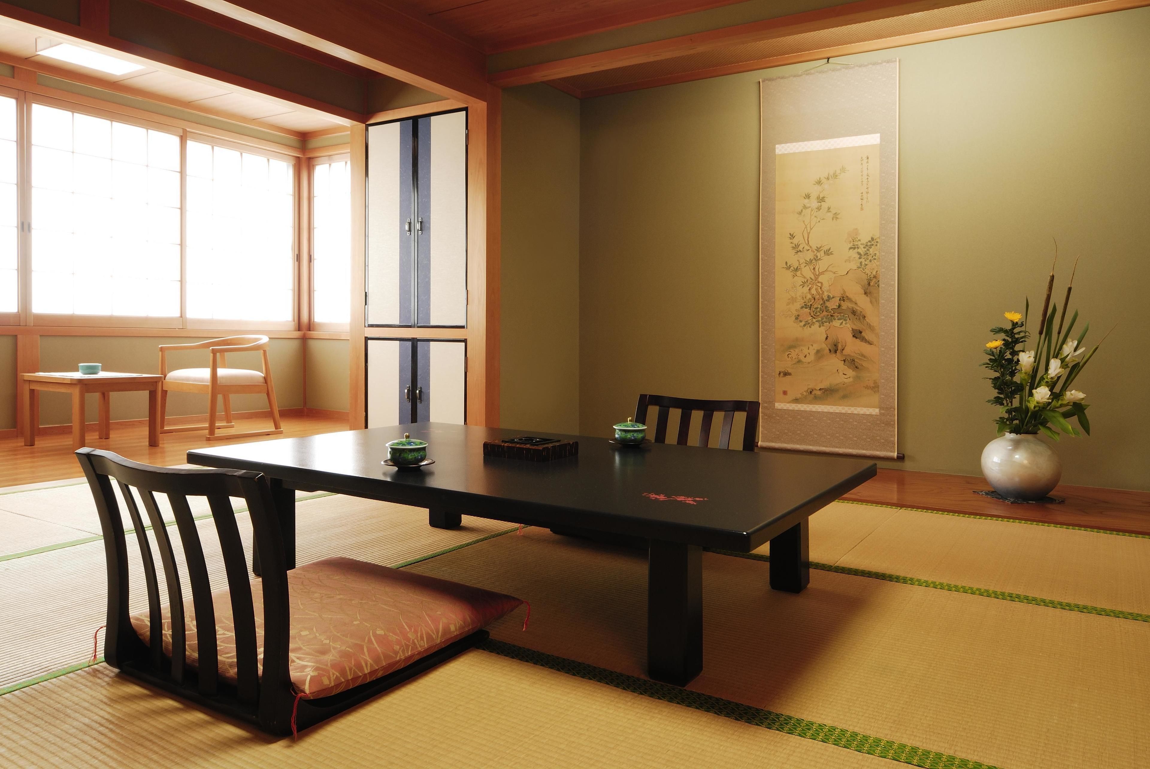 Una habitación japonesa tradicional con suelo de tatami, una mesa baja y sillas.