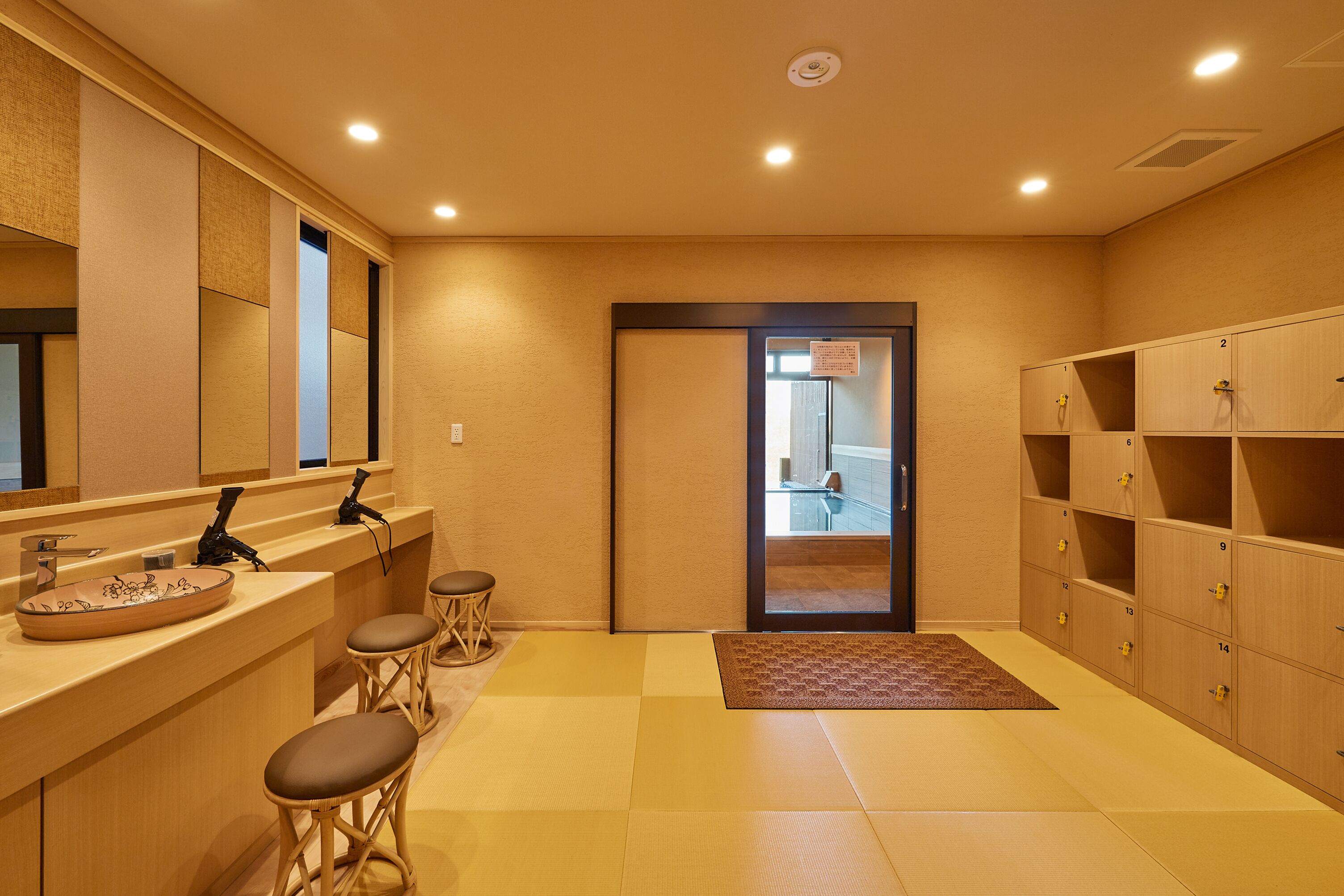 A hotel bathroom with a sink, mirror, and storage cabinets.