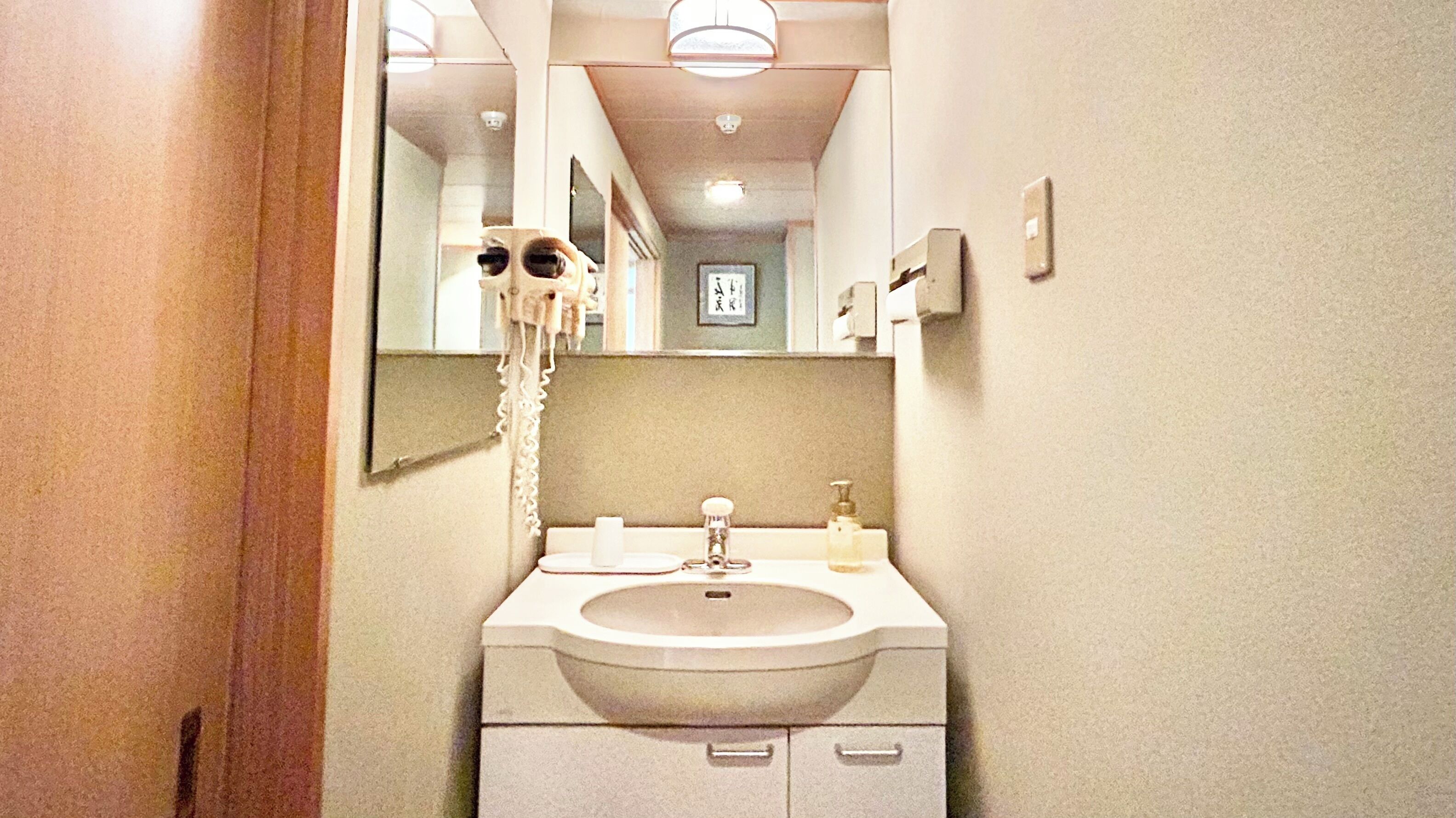 A bathroom with a sink, mirror, and a towel rack.