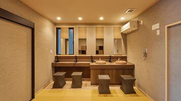 A modern bathroom with a central sink, two mirrors, and a wall-mounted air conditioner.