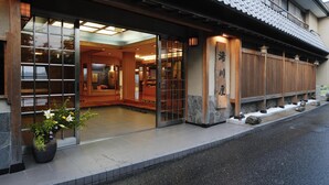 Un edificio japonés tradicional con fachada de madera, puertas de cristal amplias y tejado de tejas.