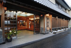 A traditional Japanese building with a wooden exterior, large glass doors, and a tiled roof.