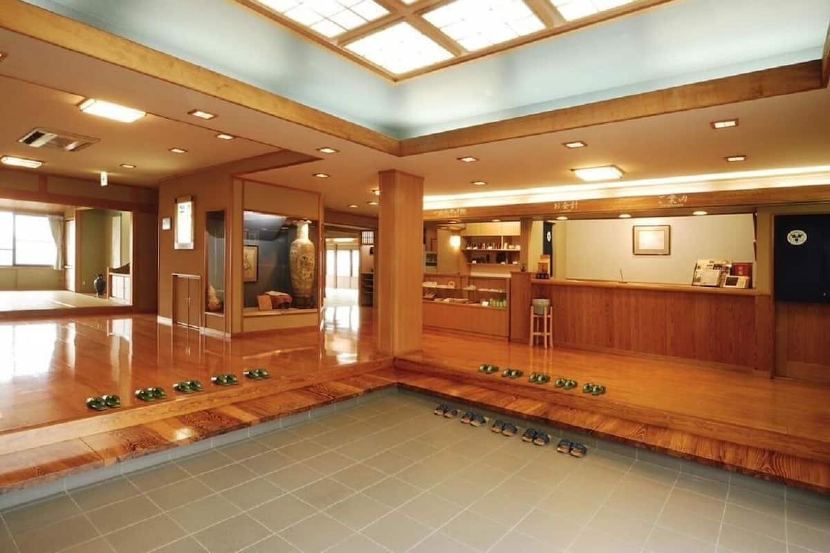 Un espacio interior amplio con suelo de madera, una pequeña piscina y un área de estar.