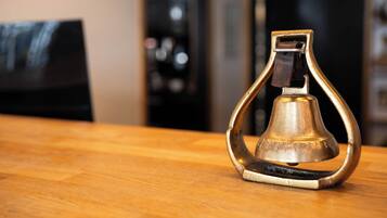 A brass bell-shaped object on a wooden surface.