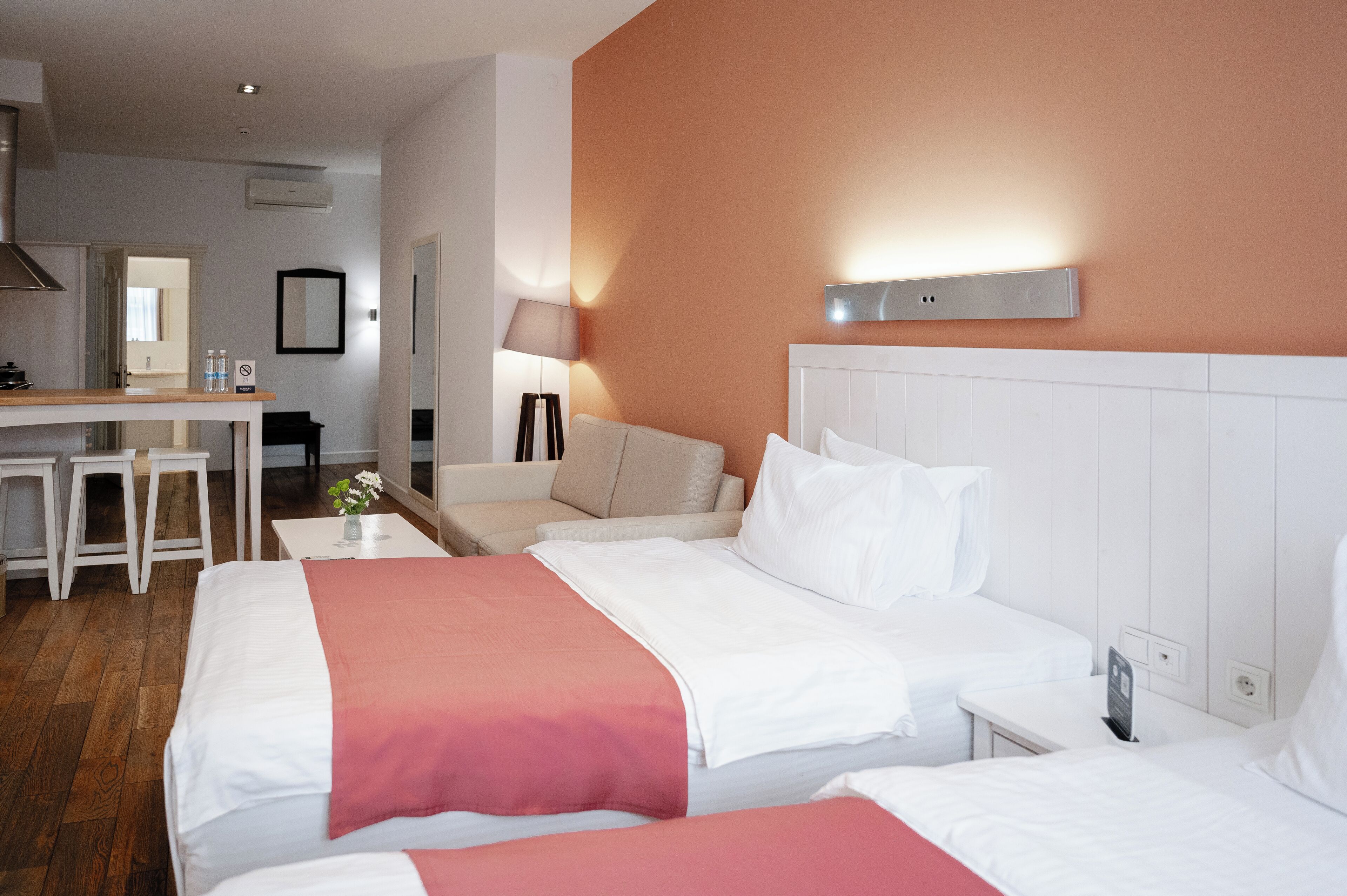 A hotel room with two beds, a desk, and a chair.