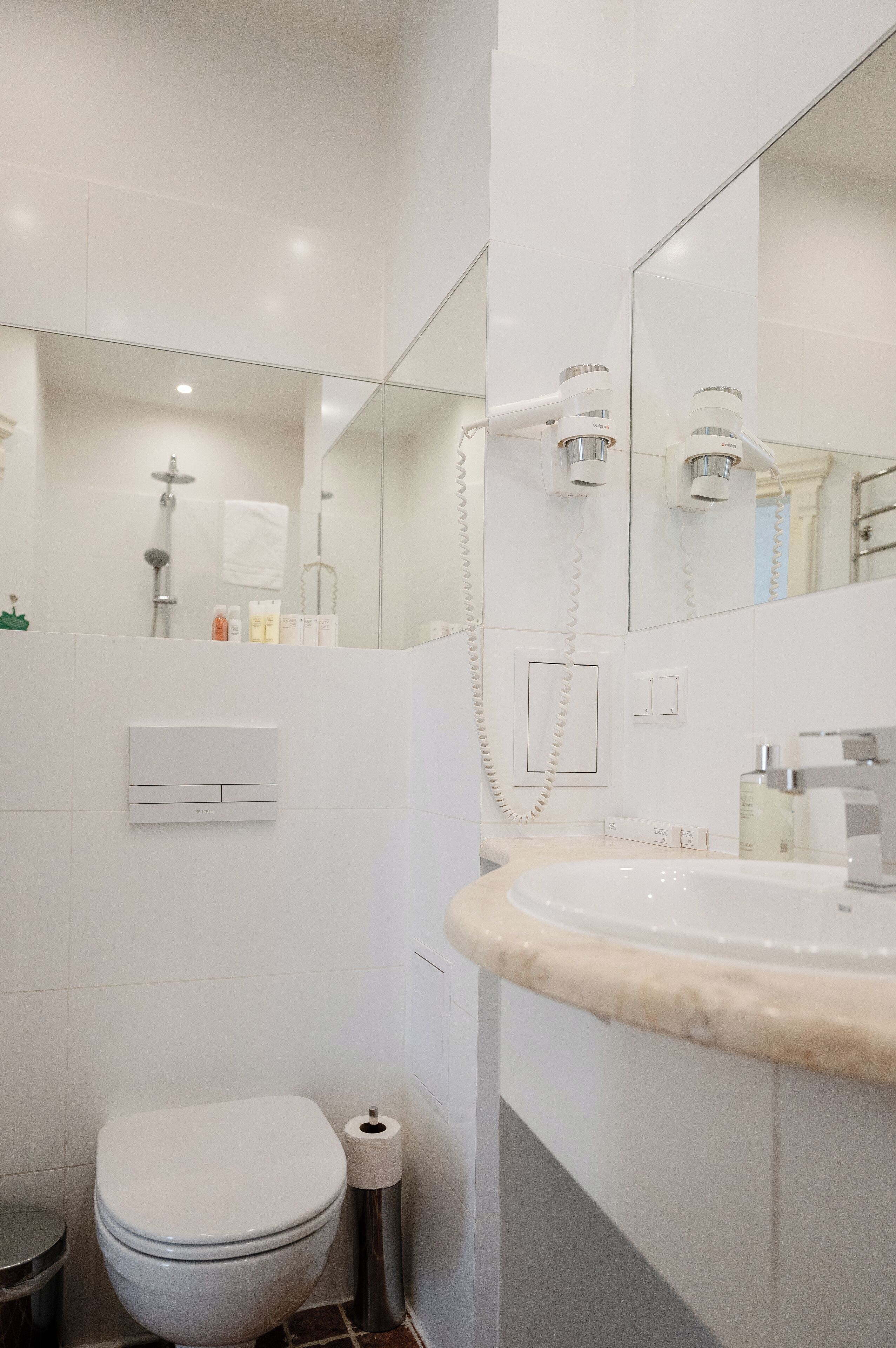 Une salle de bain moderne équipée de toilettes, d’un lavabo et d’une douche.