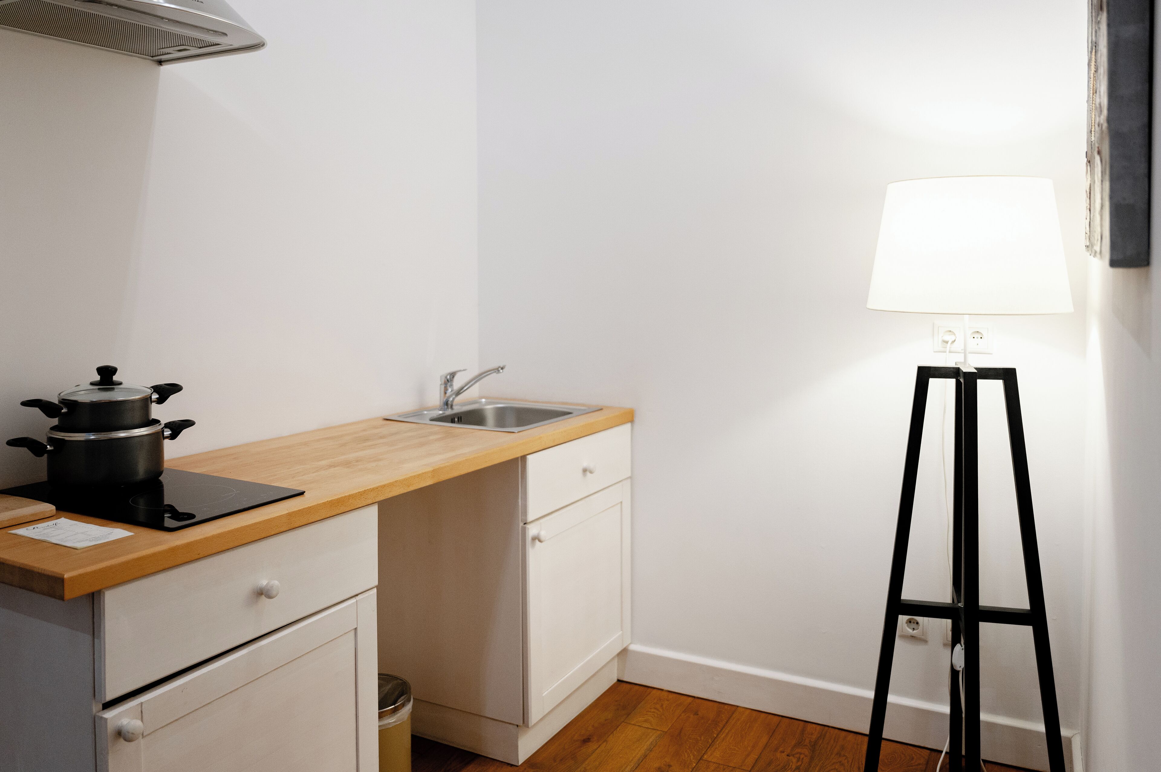 A compact kitchen with a wooden countertop, a sink, and a stove.