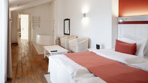Una habitación de hotel con una cama, un escritorio, una silla y una mesita.