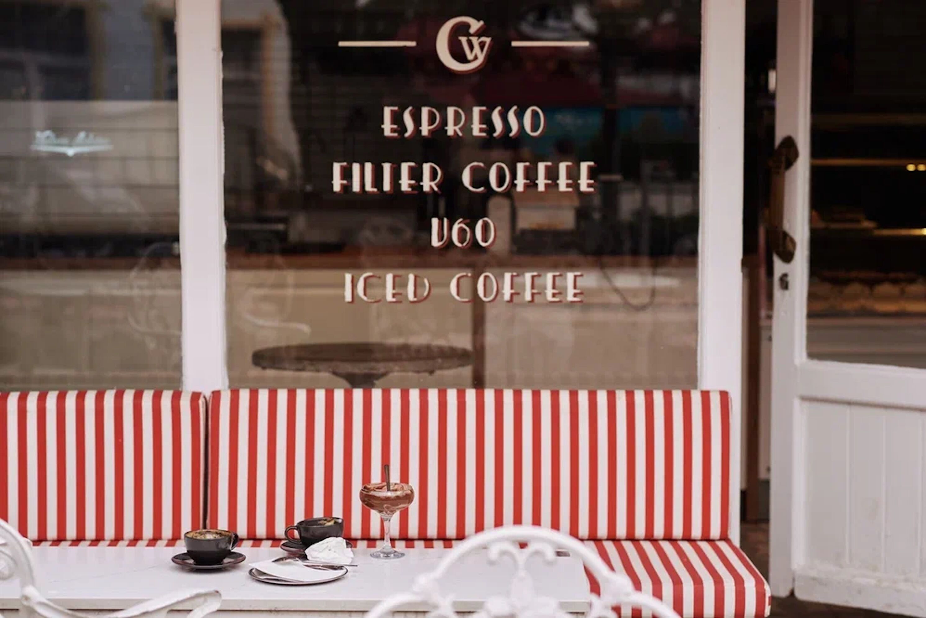 A cafe window with a menu listing espresso, filter coffee, U60, and iced coffee.