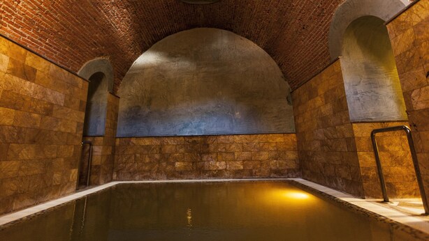 A stone-walled pool with arched ceilings and a central skylight. - Hotel Balneario de Graena (Cortes y Graena)