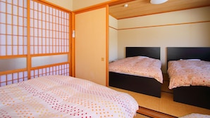 A traditional Japanese-style room with tatami flooring, a shoji screen, and a low wooden ceiling. - Yoshimura (Fujikawaguchiko)